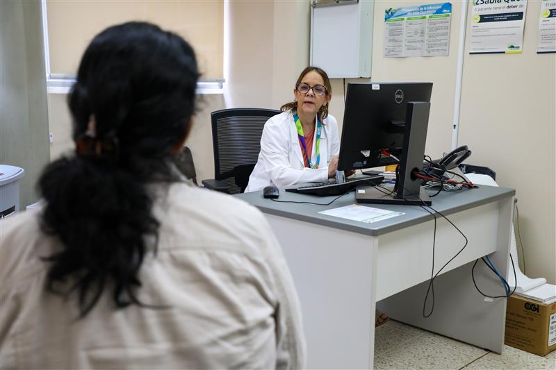 una paciente femenina de espaldas en una cita con una doctora en el consultorio